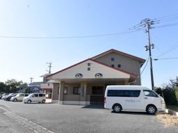 施設前の駐車場と送迎車