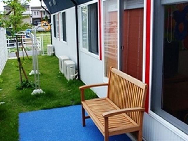 ベンチ付き屋外空間 庭 屋外にある木製のベンチが設置された休憩スペースです。緑あふれる落ち着いた景色を眺めながらの憩いのひとときをどうぞ。