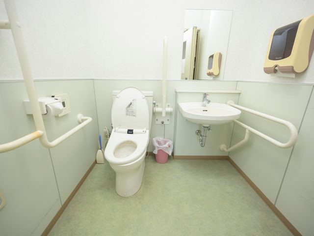 手すり付きのトイレ空間 トイレ 手すりが設置された清潔感のあるトイレです。安全かつ快適にご利用いただける環境が整っています。