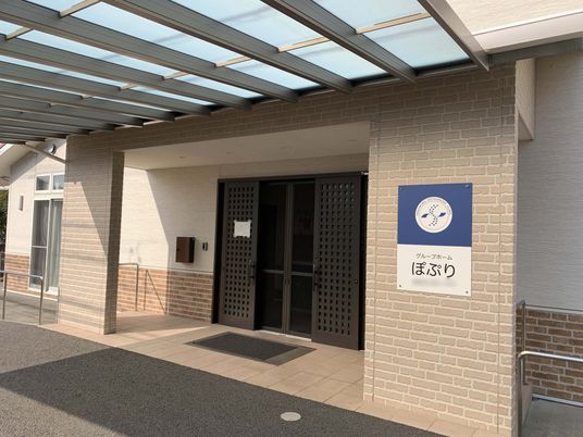 日差しと看板のエントランス