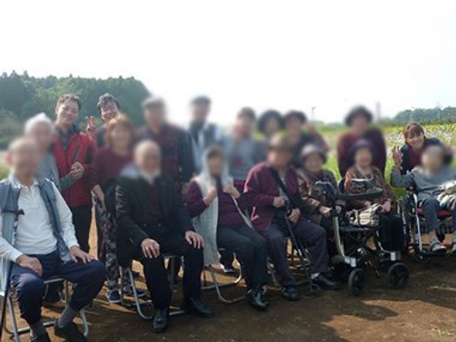 和やかな野外活動 スタッフイメージ 和やかな雰囲気の中、スタッフと入居者が野外活動を楽しんでいます。介護の現場での交流が充実しています。