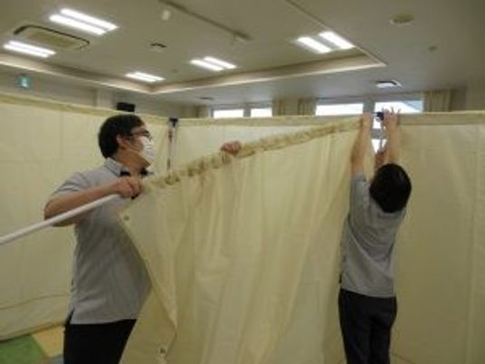 カーテンを設置する職員の様子  