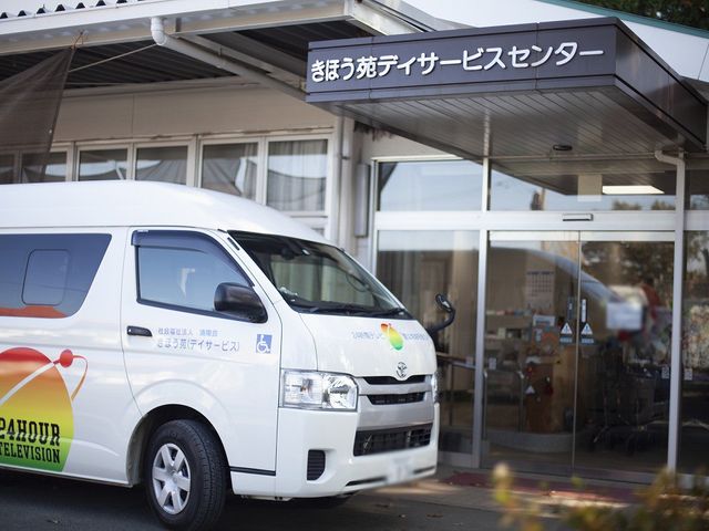 送迎車と施設玄関 エントランス 玄関前には送迎サービス用の車が停車しています。施設へのアクセスが便利です。
