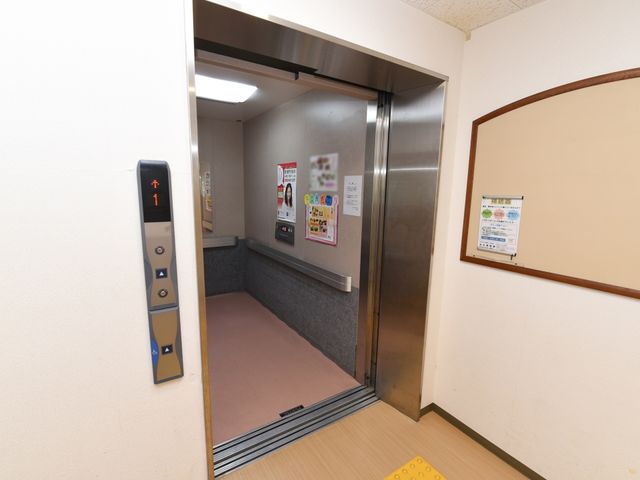清潔なエレベーターの入り口 エレベーター 広々とした入り口が印象的なエレベーターです。壁には情報コミュニケーションを助ける掲示物があり、意思疎通を円滑にします。