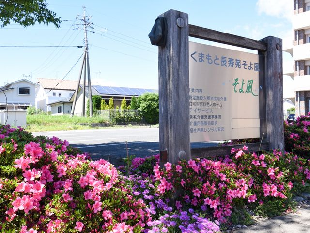 花が咲く看板 看板 周囲に花々が咲き乱れる看板が、訪れる人々を温かく迎えています。自然に囲まれた環境で働くことができる場所です。