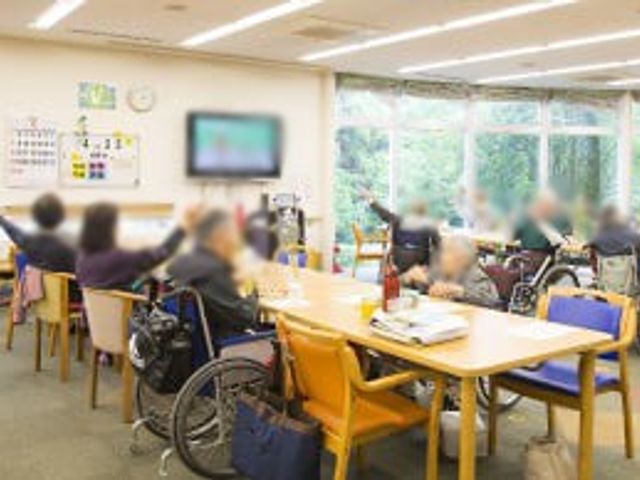 窓際の明るい空間 ラウンジ 大きな窓から自然光が入る明るいラウンジです。利用者がリラックスして過ごしています。