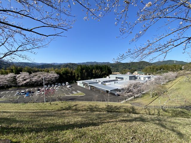 桜と山並みの施設外観  