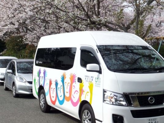 送迎車と桜の並木道  