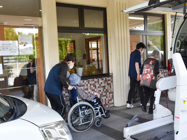 車椅子での移動支援が行われているエントランス エントランス 車椅子の移動がしやすいアプローチです。スタッフが親切にサポートする様子が見られます。