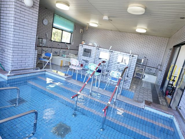 浴槽と手すりのある浴室 浴室   手すりやシャワー用のいすがあり、入浴介助を行いやすい浴室です。明るいタイル張りで、動線も確保されています。