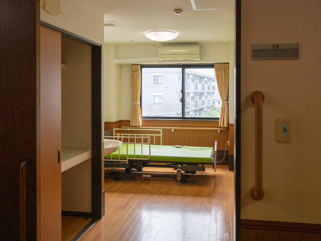 快適な居室の景観 スタッフ ゆったりとした居室は窓から自然光が差し込み、明るく安らげる雰囲気を提供しています。ベッド脇には手元を照らすための照明も完備しており、夜間でも快適です。