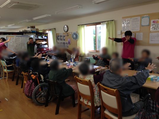運動する集団がいる室内