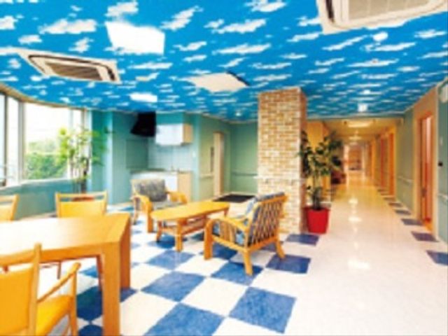 青空模様の廊下スペース 談話室 ポップなデザインが施された明るくゆったりとした廊下です。訪れる人々がホッと落ち着けるような雰囲気があります。