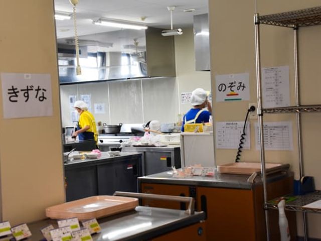 調理中のキッチン キッチン スタッフが調理を行っているキッチンです。清潔な設備で、安心して作業ができます。