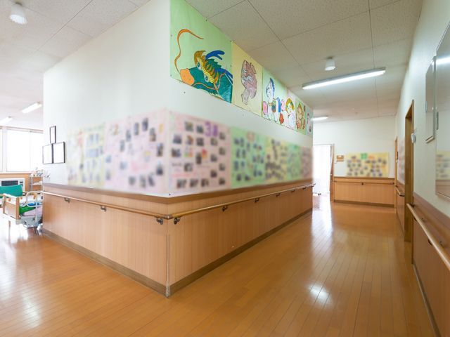 明るい廊下の絵画装飾 廊下 廊下には色鮮やかな絵画が飾られ、訪れる方々の目を楽しませています。掲示されている写真コラージュも、コミュニケーションのきっかけを提供してくれそうです。
