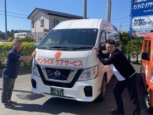 送迎車を支える男性2人の外観  