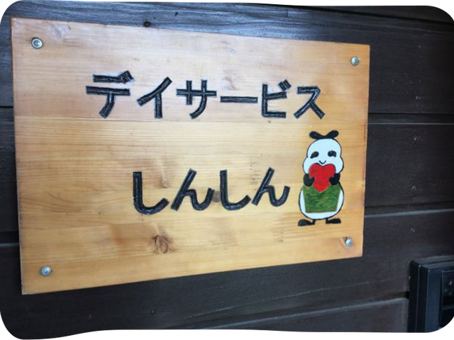 デイサービス看板 看板 温かみのあるデザインの看板が設置されています。見守るように描かれた絵が印象的です。