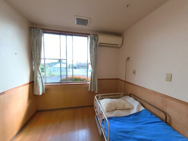 明るい窓辺の居室 居室 自然光が入る明るい居室で、ゆったりとしたベッドが備えられています。くつろぎの時間が過ごせます。