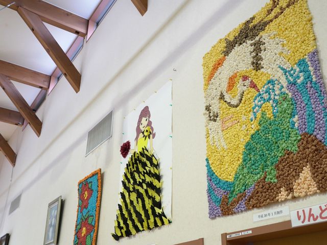 子ども作品の壁 ロビー 壁に展示されたカラフルな子どもたちの作品が、温かな雰囲気を演出しています。