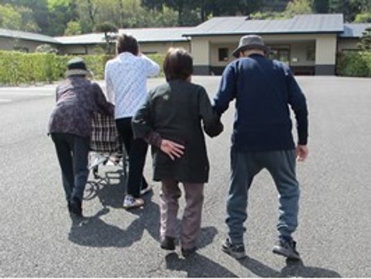 散歩する入居者と職員