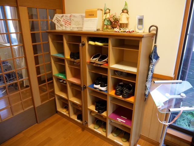 温かみのある玄関エリア エントランス 木目調の棚には靴が丁寧に収納されており、訪れる方を温かく迎える玄関エリアです。