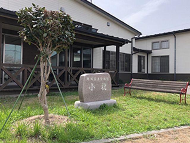 中庭の風景と石碑がある施設 中庭 緑豊かな中庭で、利用者さまと共に心地よい時間を過ごせるやりがいのある職場環境です。