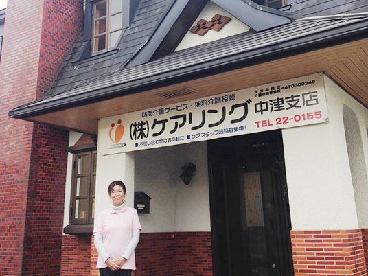 施設前で立つ職員  