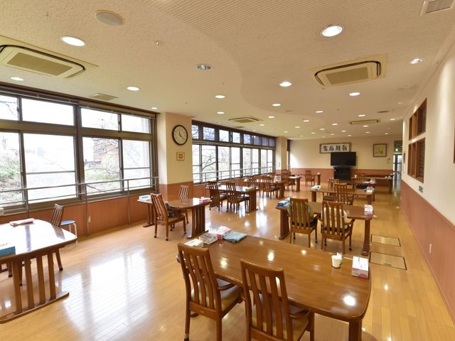 窓辺の明るい食堂 共有スペース 陽光が差し込む、ゆったりとした食堂で、利用者様は毎日の食事を楽しまれています。木製のテーブルと椅子が温かい雰囲気を演出しております。