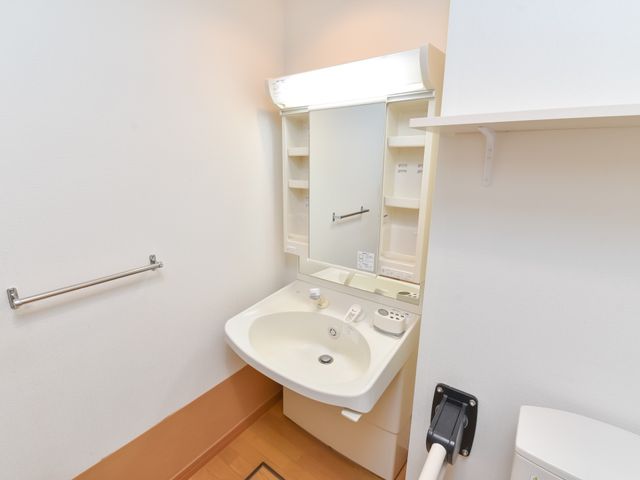 清潔な洗面台スペース 洗面台 手すり付きの洗面台は安全で使いやすく、個々のニーズに合わせた配慮がされています。清潔感のあふれる空間で、快適にご利用いただけます。