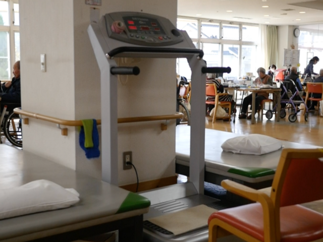 運動器具のある室内 機能訓練室 自然光がたっぷり入る明るい空間で、運動やリハビリが快適に行えます。利用者がリラックスした様子で過ごせる施設です。
