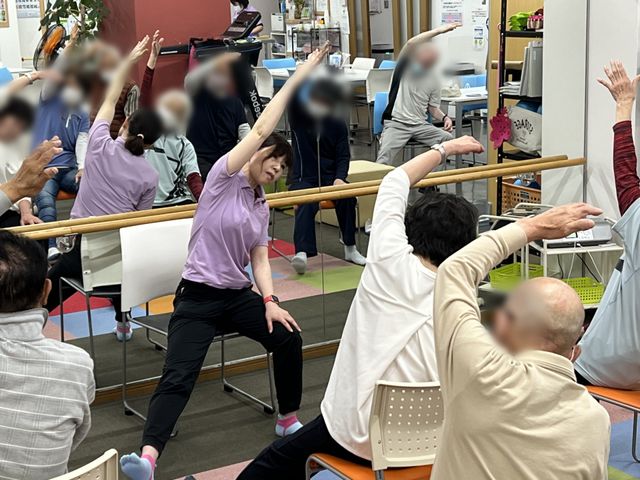 運動に取り組む人々の部屋 機能訓練室 仲間と一緒にリラックスしながら身体を動かせるスペースがあります。運動を楽しむ様子がうかがえます。