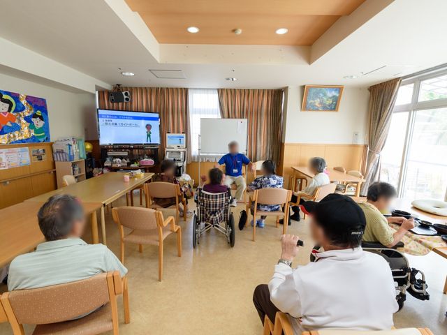 リビングの様子 食堂 広々とした明るいリビングでは、入居者の方々がテレビを見たり、談笑したりして過ごされています。自由な時間を大切にする温かい環境です。