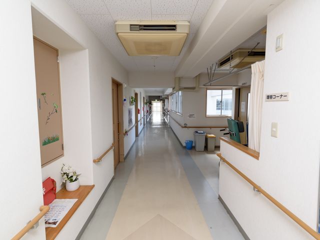 廊下と掲示ボード 廊下 ゆとりあるスペースの廊下で、入居者様が安心して歩けるよう手すりが完備されており、壁面には季節の飾り付けがされています。