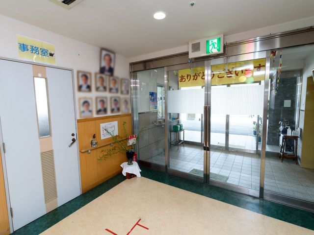 エントランスの様子 玄関 明るく開放的な入口には温かな雰囲気があり、訪れる方をやさしく迎え入れます。種々の案内と暖かな挨拶が、新しい仲間を待っています。