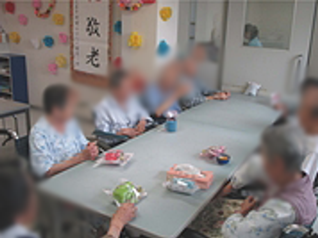 和やかな交流の場 多目的室 広いテーブルを囲み、利用者同士が和やかに会話を楽しむ場です。温かい雰囲気に包まれています。