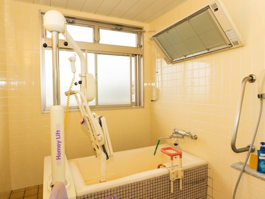 浴槽と介助用機器のある浴室  