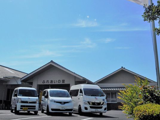 駐車された車と施設入口