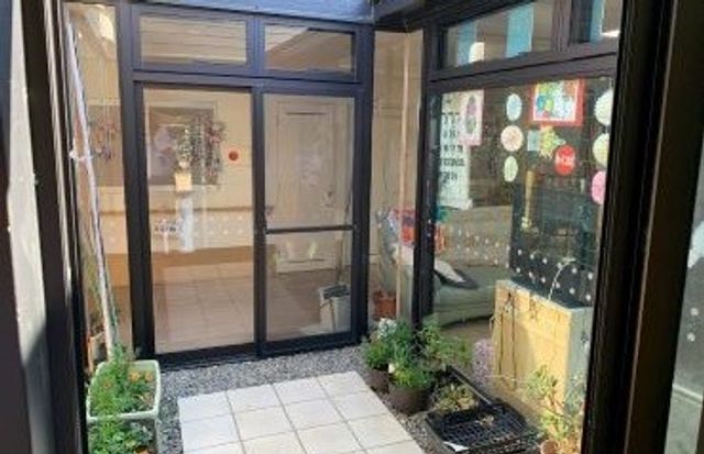 窓際の明るい廊下 廊下 自然光が差し込み、鉢植えの植物が置かれた心地よいスペースです。掲示物もあり、情報が豊富です。