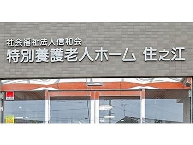 看板前の風景 看板 施設の名称が刻まれた入り口です。温かみのあるデザインが特徴です。