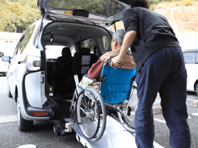車椅子の乗降風景 外観 車椅子の方が介助を受けて乗降できます。快適で支え合える環境を提供しています。