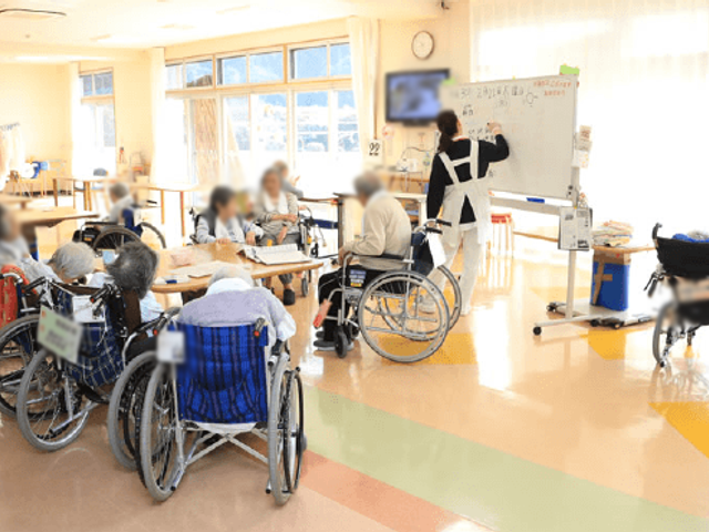 自然光あふれる活動室 多目的室 広々とした空間で、活動に取り組む利用者の様子です。明るい環境がサポートをしています。