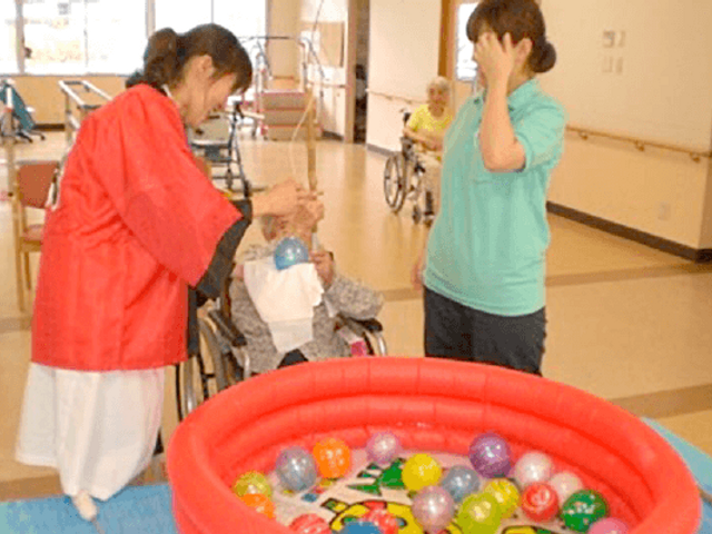 楽しむ入居者の日常 多目的室 入居者が多目的スペースでボールすくいを楽しんでいます。車椅子の方も参加可能です。