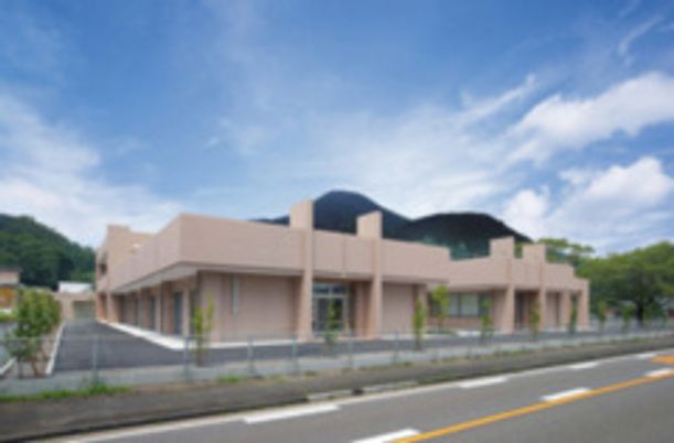 雄大な山を背景にした外観