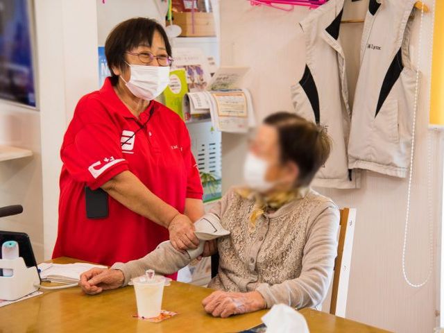 スタッフと利用者の様子 リビング スタッフが利用者に寄り添い、和やかに過ごせるリビングです。安心感のある空間となっています。