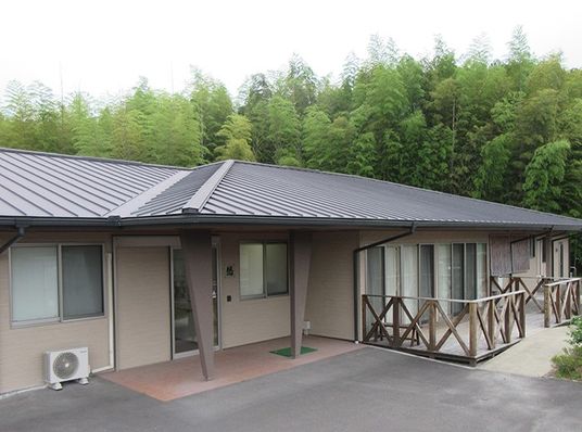 緑に囲まれた平屋の外観  
