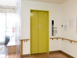 黄色いエレベーターの扉と廊下