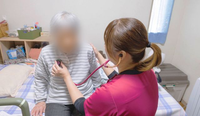 スタッフによる健康チェックの居室 居室 スタッフが入居者の方の健康状態を丁寧に確認しています。快適な居室で安心して過ごせます。