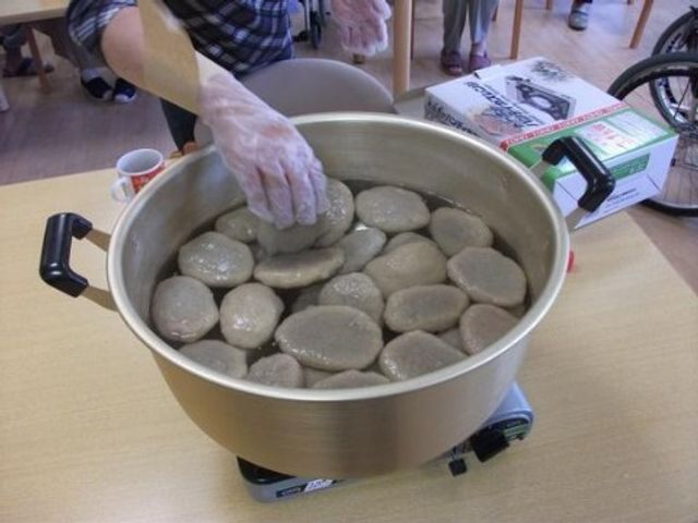 石を並べた活動風景 レクリエーション 手作業で創造性を育むアクティビティが行われており、利用者の方々の表情も和やかです。