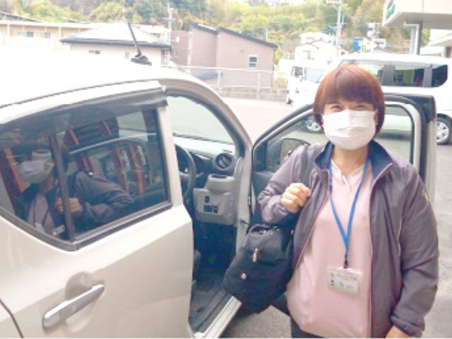 スタッフと車イメージ スタッフイメージ 笑顔で寄り添うスタッフが安心感を与えます。移動のお手伝いも丁寧に行う環境です。