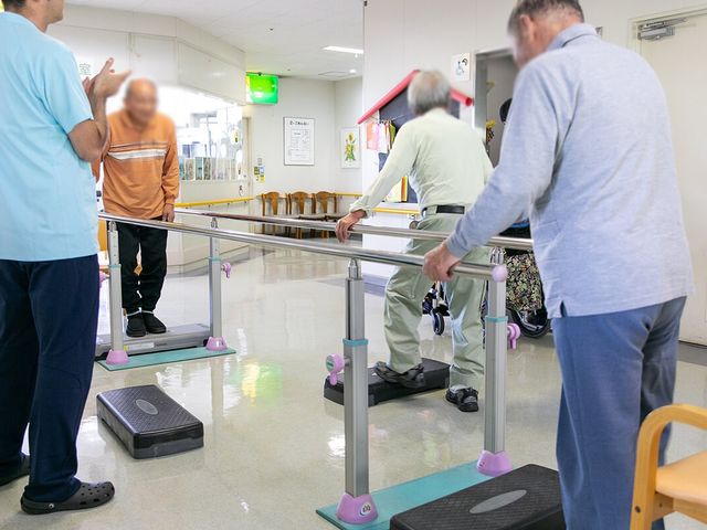 リハビリの様子訓練室 機能訓練室 利用者がリハビリを楽しむ明るい空間です。スタッフが優しくサポートしています。